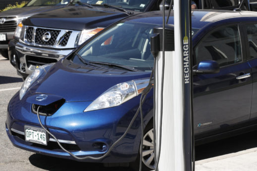 In this Tuesday, June 26, 2018, photograph, a Nissan Leaf charges at a recharge station while parked by the Denver City/County Building in downtown Denver. (AP Photo/David Zalubowski)