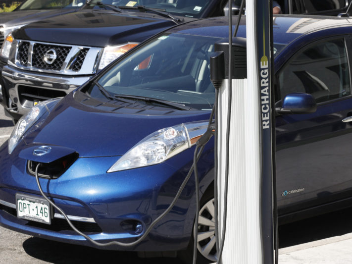 In this Tuesday, June 26, 2018, photograph, a Nissan Leaf charges at a recharge station while parked by the Denver City/County Building in downtown Denver. (AP Photo/David Zalubowski)