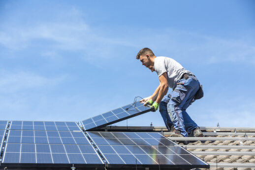 Installing solar photovoltaic panel system. Solar panel technician installing solar panels on roof. Alternative energy ecological concept.