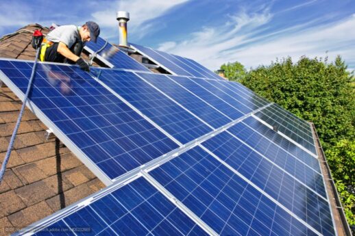 Man-installing-alternative-energy-photovoltaic-solar-panels-on-roof